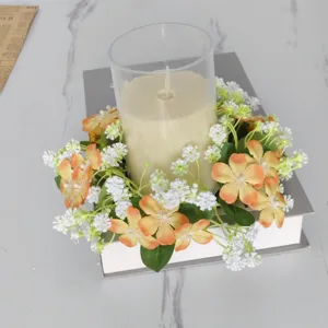 Pastorale wilde bloemen kaarsenring met glazen houder op een decoratieve boeksteun