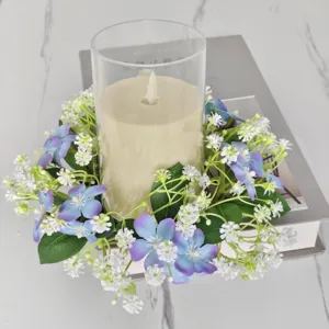 Detail van kunstmatige wilde bloemen kaarsenkrans met glazen houder op marmeren tafel