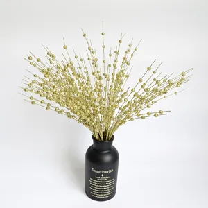 Close-up of golden glitter foam berry stems for festive Christmas home decor in black vase