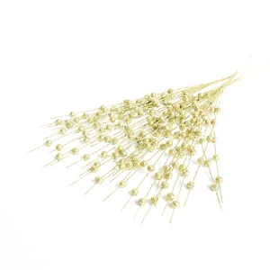 Close-up macro view of artificial gold glitter stems with small foam balls décor