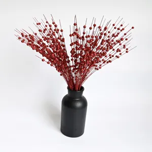 Detailed view of red glitter foam berry stems in a sleek minimalist black matte vase.