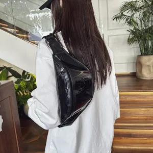 Detailed view of a trendy black glossy chest bag showing its sleek material and zipper design.