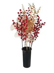 Detalle de bayas rojas artificiales y hojas de ginkgo doradas en un jarrón negro