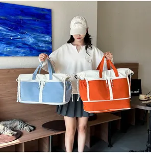 Close-up showing large capacity travel bags in vibrant blue and orange held by model