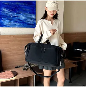 Woman holding black large capacity travel bag with shoulder strap in a cafe