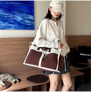 Large capacity brown canvas travel bag with adjustable strap shown on model.