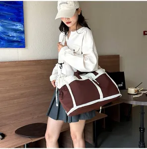Spacious brown and white travel duffel bag for gym and outdoor sports shown on model