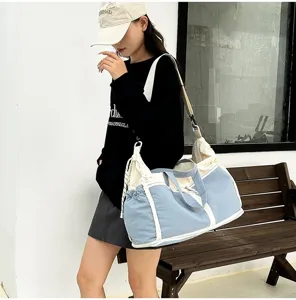 Detail view of a large blue and white canvas multifunctional travel bag carried by a woman.