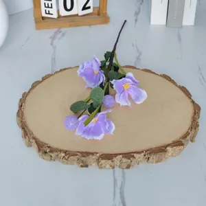 Close-up detail of three-headed purple artificial poppy flowers on a wooden slice