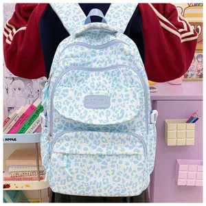 Detailed view of a light blue leopard print student backpack in a cozy study setting.