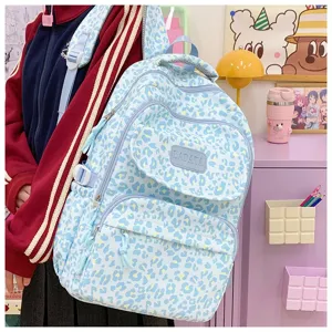 Detailed view of a light blue leopard print large capacity backpack worn in a lifestyle setting