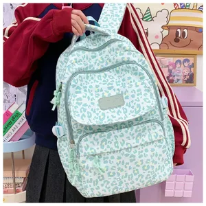 A student carrying a mint green leopard print backpack in a vibrant school setting.