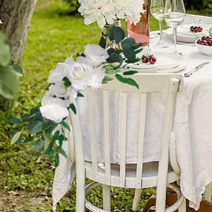 Elegante decorazione floreale di rose bianche ed eucalipto per schienale sedie da matrimonio.
