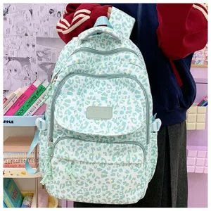 Detailed view of the light green leopard print backpack with multiple zip pockets