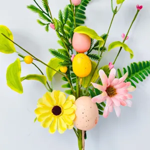 Künstlicher Osterblumenzweig mit bunten Ostereiern und Beeren für festliche Heimdekoration.