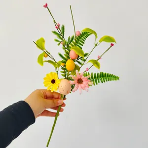 Kuenstlicher Osterblumen Zweig mit bunten Eiern und Beeren fuer die feiertagliche Dekoration.