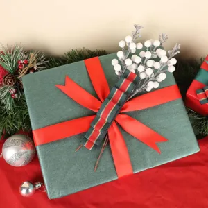 Nahaufnahme von weißen, glitzernden künstlichen Weihnachtsbeeren auf einem Geschenk.