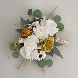 Elegante Nahaufnahme eines Hochzeitsgestecks mit weißen und goldenen Kunstrosen
