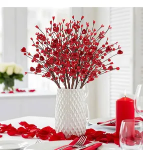 Primo piano di steli di bacche rosse a forma di cuore per San Valentino in vaso bianco.