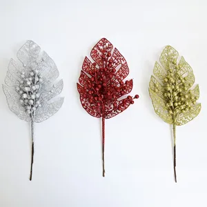 Glitter artificial monstera leaf with berries, Christmas tree decoration closeup view.