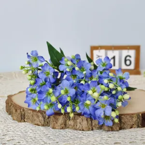 Detailed close-up of blue artificial flower bouquet on natural wood slice decor prop
