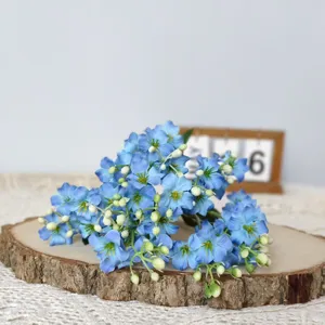 Detailed view of blue artificial paulownia flowers bouquet on wood slice for home decor.