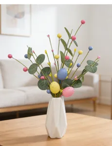 Detail of Easter egg berry branches with eucalyptus leaves in a white vase decoration.