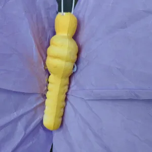 Detailed close-up of purple paper butterfly wing and yellow body wedding decor prop.