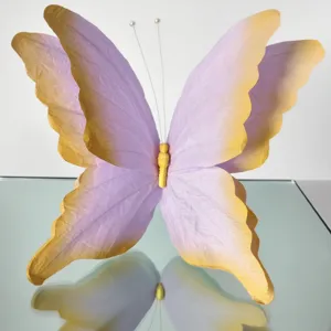 Close-up view of gradient purple 3D paper butterfly art prop for wedding event decoration.