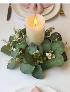 Macro detail of artificial eucalyptus candle ring wreath on a festive dining table setting