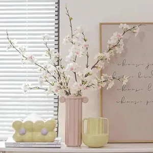 Artificial cherry blossom branches with pink vase for home decor, spring floral arrangement.