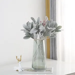 Detailed view of artificial flocked rabbit ear leaves flowers bouquet in a glass vase for home decor.