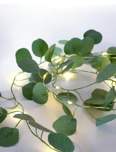 Detailaufnahme einer künstlichen Eukalyptusgirlande mit warmen LED-Lichterketten