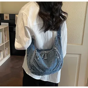 Detailed back view of a vintage denim dumpling shoulder bag showing texture and zippers