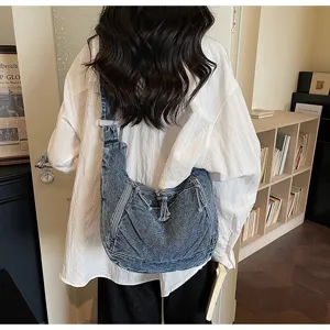 Back view of a large vintage denim dumpling bag worn by a person