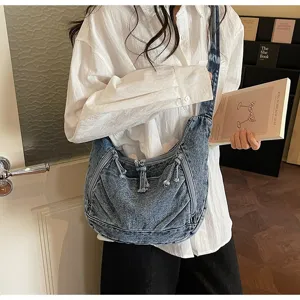 Model wearing retro blue denim crescent shoulder bag for lifestyle display