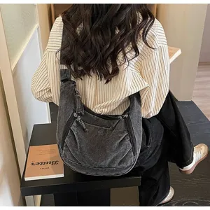 Detailed view of a retro large-capacity dark grey denim dumpling bag worn on the shoulder.