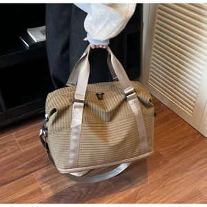 Women's large capacity checked travel duffel bag shown in a lifestyle indoor setting