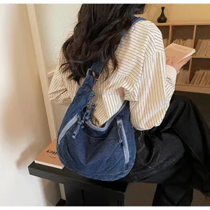 Detailed view of a retro blue denim hobo bag with zipper design on a shoulder strap