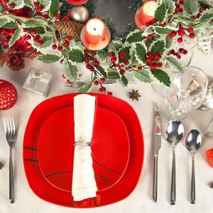 Detailed view of artificial Christmas garland with red berries on a festive table setting