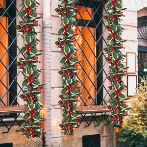 Realistic artificial Christmas garland with vibrant red berries and green holly leaves.
