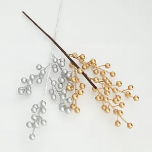 Close-up of artificial golden and silver berry branches for floral arrangement and home decor.