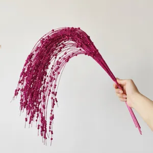 Primo piano di rami di bacche glitterate fucsia per decorazioni natalizie festive