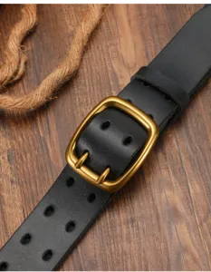Detailed view of vintage brass double pin buckle on black genuine leather belt