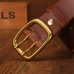 Retro brown leather men belt with a vintage golden metal pin buckle closeup view.