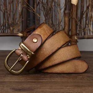 Close-up of a 3.3cm wide vintage distressed brown leather belt with brass buckle
