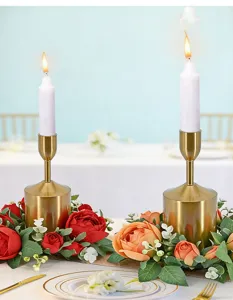 Primer plano de candelabros dorados con coronas de rosas para decoración de bodas