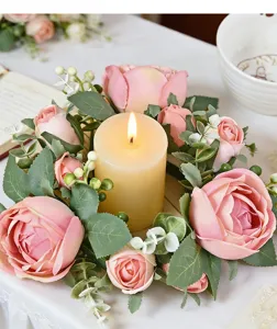 Primer plano de corona para vela artificial con capullos de rosa rosa y eucalipto