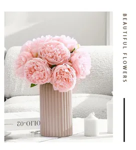 Detail of artificial peony flower bouquet in fluted vase for home and wedding decor setup.