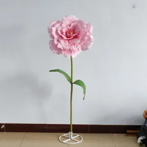 Detail view of giant artificial pink peony flower prop with stem and metal base for decor.